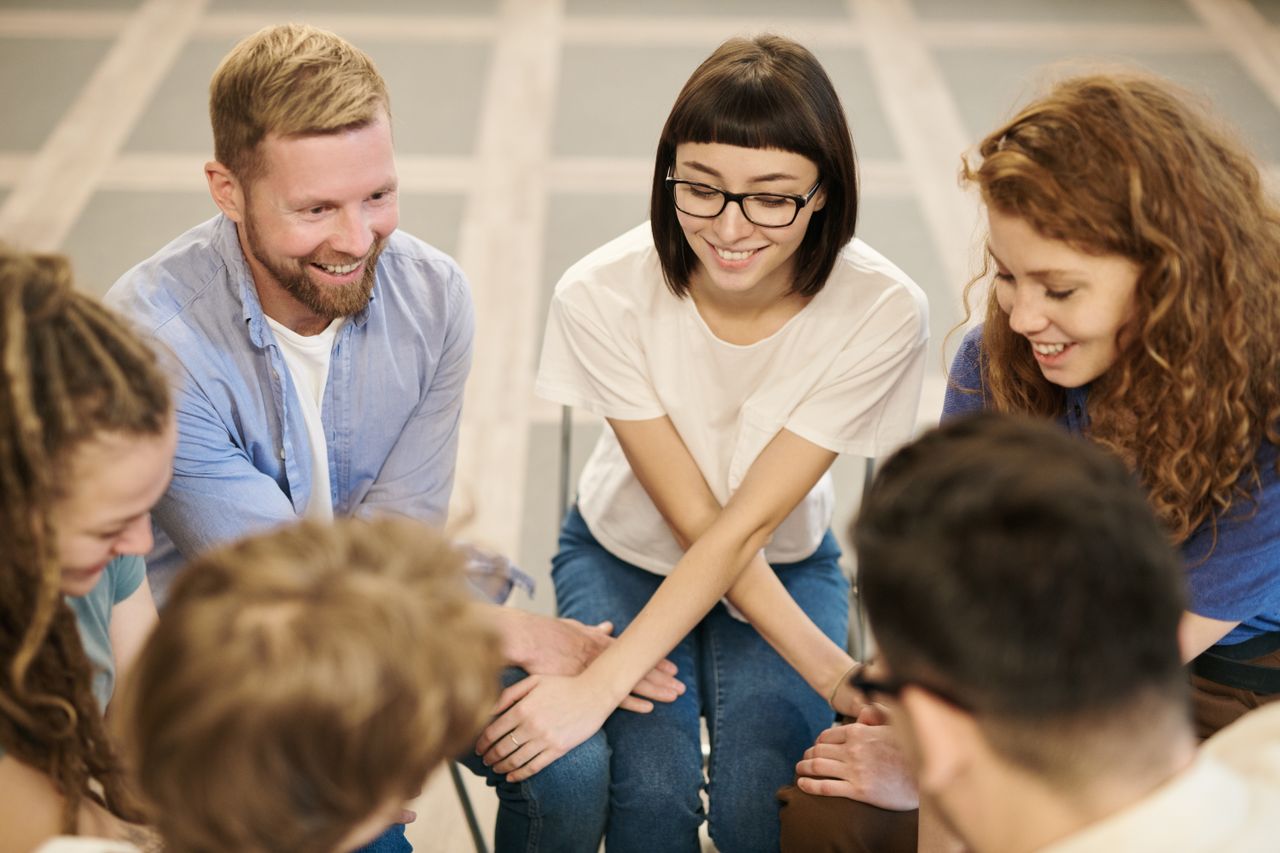 why-choose-us A diverse group of adults laughing and bonding together in an indoor setting.